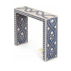 Op de afbeelding: Een rechthoekige consoletafel met een crèmekleurige basis, voorzien van ingewikkelde donkerblauwe bloemenrank-inleg op de poten en een kronkelend rankpatroon op het blad, omrand door een geometrisch ruitpatroon in donkerblauw en crème.