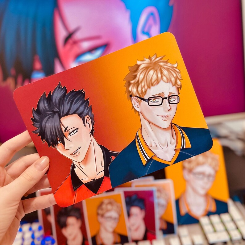 Puede incluir: Impresi&oacute;n rectangular con dos personajes de estilo anime. Uno tiene el pelo negro y lleva una camiseta roja y negra, el otro tiene el pelo rubio, gafas y una camiseta azul. El fondo se desvanece de rojo a naranja. Se ven varias impresiones similares.