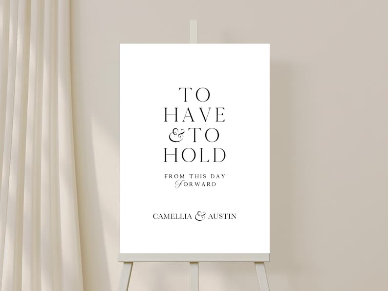 May include: A white wedding sign with black text that reads "To Have & To Hold From This Day Forward Camellia & Austin".
