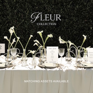 May include: A white tablecloth with a table setting for a wedding or special event. The table is decorated with white calla lilies in glass vases, silver plates, and white place cards. The text "Fleur Collection" and "Matching Assets Available" is printed on the tablecloth.
