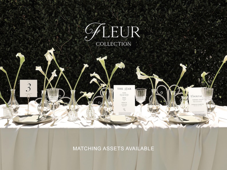 May include: A white tablecloth with a table setting for a wedding or special event. The table is decorated with white calla lilies in glass vases, silver plates, and white place cards. The text "Fleur Collection" and "Matching Assets Available" is printed on the tablecloth.