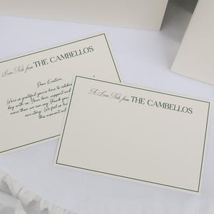 May include: Ivory stationery set featuring a handwritten note from "THE CAMBELLOS" with a green border. The text includes a message of gratitude. A matching blank card and a table card are also visible.