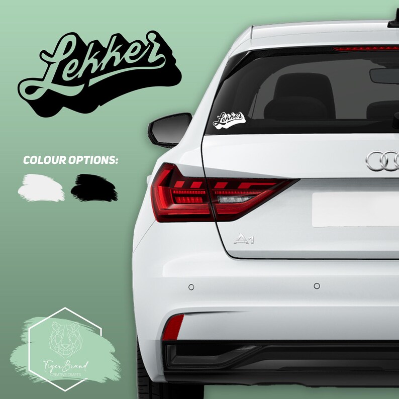 May include: A white car with a black and green "Lekker" sticker on the back window. The sticker is available in white or black.