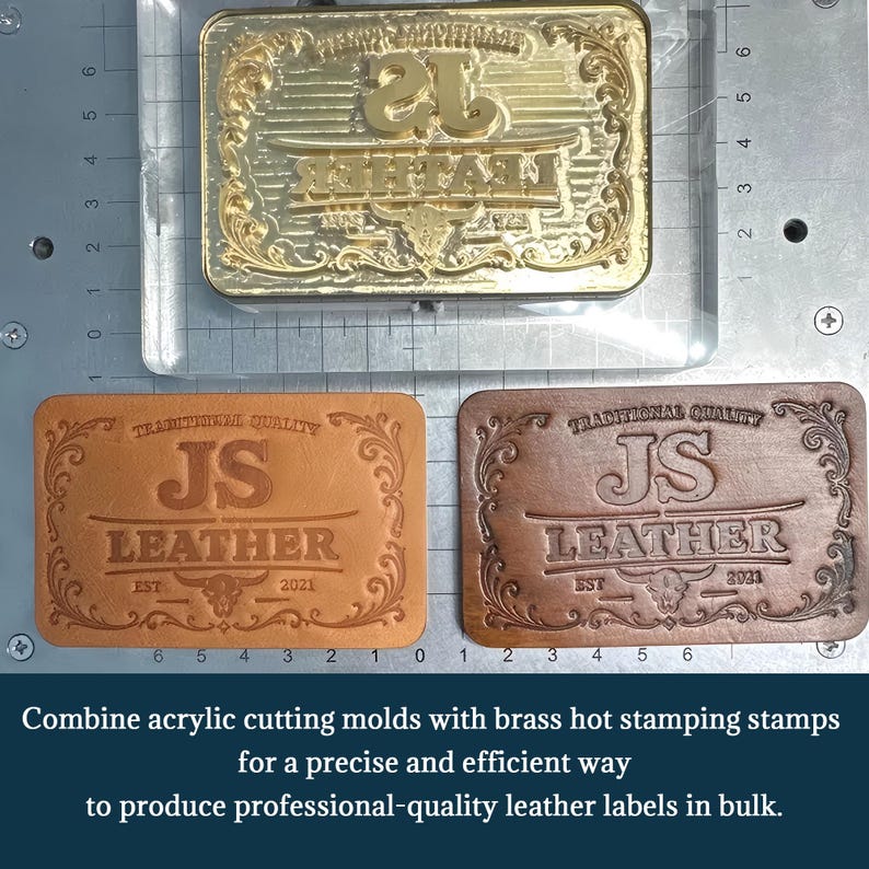 May include: A gold-coloured brass hot stamping stamp featuring the text JS LEATHER, TRADITIONAL QUALITY, and EST 2021, positioned above two rectangular leather labels with the same embossed design in light tan and dark brown leather colours.