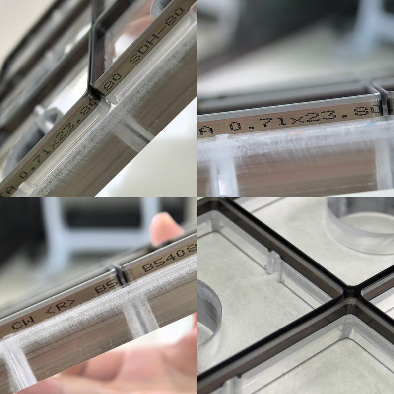 May include: A clear plastic grid organiser with dark brown edges. The frame features printed text including 0.71x23.80, SDH-80, and B5408. The structure consists of multiple rectangular compartments with thin, transparent walls and dark brown trim.