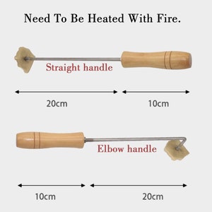 May include: Two metal tools with wooden handles for making leather crafts. The tool on the top has a straight handle and the tool on the bottom has an elbow handle. Both tools are 20 cm long and 10 cm wide. The text "Need To Be Heated With Fire." is at the top of the image.