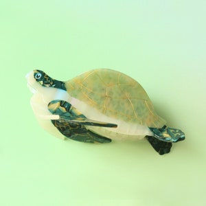May include: A green and gold turtle figurine with a detailed shell and a realistic appearance.