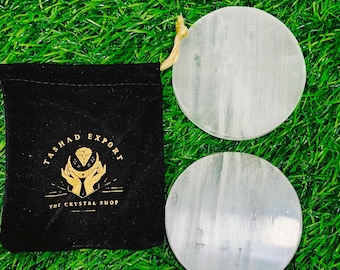 May include: Two white selenite charging plates with a black velvet pouch that says "Tasha Export The Crystal Shop" in gold lettering.
