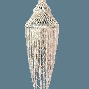 Peut inclure: Un lustre blanc en perles avec un sommet tissé et des brins de perles en cascade.