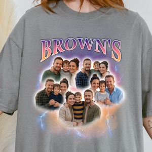 May include: Gray t-shirt featuring a family photo collage with the text "BROWN'S" in a colorful, stylized font. The design includes multiple family portraits surrounded by a cloud and lightning effect.