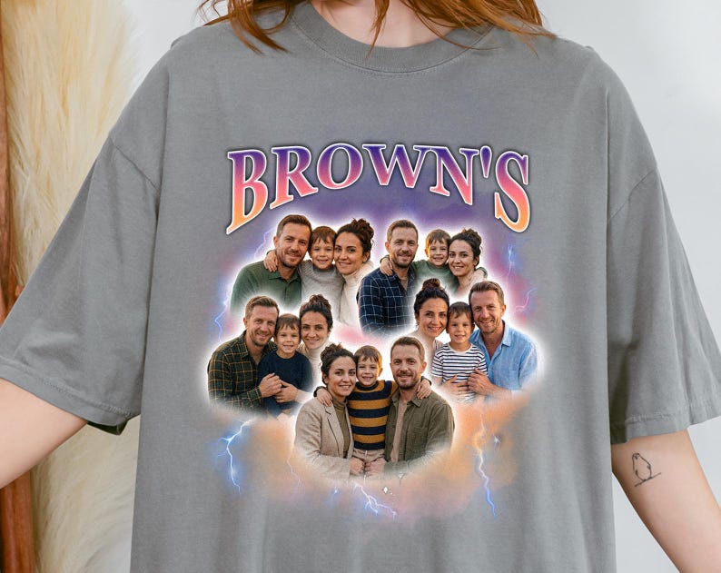 May include: Gray t-shirt featuring a family photo collage with the text "BROWN'S" in a colorful, stylized font. The design includes multiple family portraits surrounded by a cloud and lightning effect.