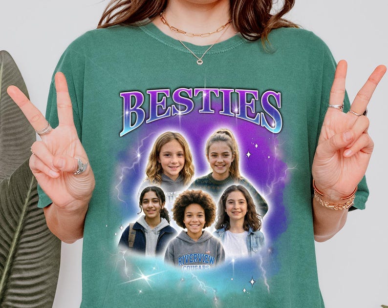 May include: Green t-shirt with the word "BESTIES" in a purple and blue design. The shirt features a graphic of five smiling girls in front of a purple and blue background with lightning bolts. The shirt also has the text "RIVERVIEW COUGARS".