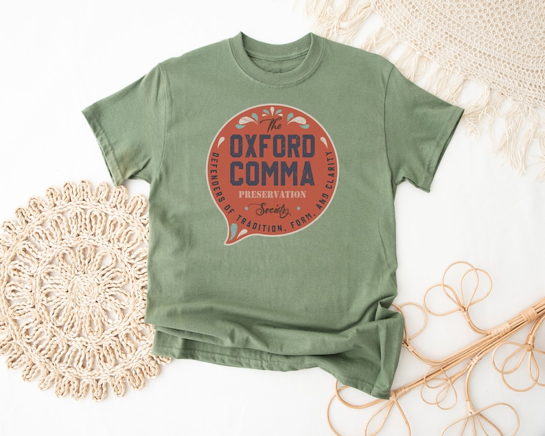 May include: A green t-shirt with a red circle graphic that says "The Oxford Comma Preservation Society. Defenders of Tradition, Form, and Clarity."