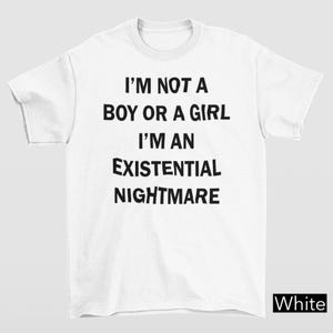 Könnte beinhalten: Weißes T-Shirt mit dem schwarzen Text: "I'M NOT A BOY OR A GIRL I'M AN EXISTENTIAL NIGHTMARE". Das Wort "White" befindet sich in einem weißen Feld unten rechts.