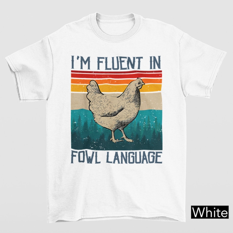 May include: White t-shirt with a vintage-style graphic of a chicken and the text "I'm fluent in fowl language".
