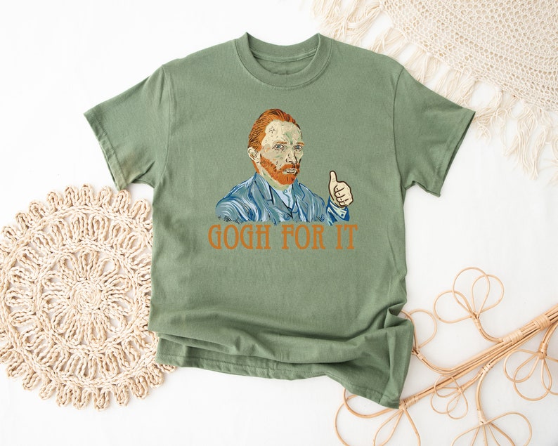 May include: Green t-shirt with a painting of Vincent Van Gogh giving a thumbs up. The text "GOGH FOR IT" is printed below the image.