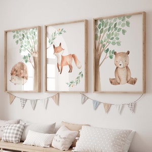 May include: A light wood bench with six storage bins, decorated with a garland of colorful flags. Three framed watercolor prints of woodland animals hang above the bench. The prints feature a fox, a hedgehog, and a bear.