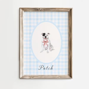 May include: A framed watercolor print featuring a seated dog with a red and white bow tie, set against a light blue gingham pattern. The dog is within a light blue oval, with the name "Patch" written below in cursive.