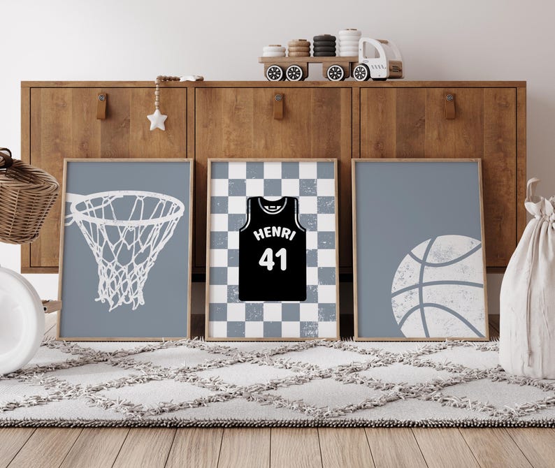 May include: Three framed prints with a basketball theme. One shows a white basketball net on a blue background. Another features a black jersey with "HENRI 41" on a checkered background. The third print displays a white basketball on a blue background.