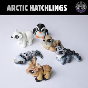 May include: A collection of six articulated animal figurines labelled Arctic Hatchlings, including a white polar bear, a black and white penguin, a tan walrus, a grey spotted narwhal, a grey spotted snow leopard, and a tan reindeer.