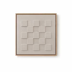 Pu&ograve; includere: Un'opera d'arte murale quadrata con un motivo a scacchiera testurizzato color beige chiaro all'interno di una cornice in legno naturale. Il design &egrave; composto da quadrati lisci in rilievo alternati a quadrati con sottili linee verticali.
