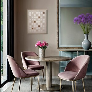 K&ouml;nnte beinhalten: Ein Esszimmer mit einem runden Tisch auf einem Messingfu&szlig;, umgeben von drei rosa Samtst&uuml;hlen mit goldenen Beinen. Eine Vase mit rosa Rosen schm&uuml;ckt den Tisch. Ein abstraktes Kunstwerk h&auml;ngt an der Wand und ein gro&szlig;er Spiegel ist sichtbar.