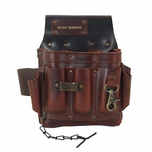 May include: Brown leather tool belt with multiple pockets and a metal buckle. The belt has a black leather flap with the text "WIDE BROWN" embossed in gold.