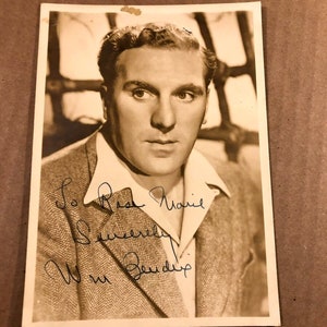 May include: A vintage sepia photograph featuring a man in a collared shirt and a tweed jacket. The image includes handwritten text: "To Best Marie, Sincerely, Wm. Bendix."