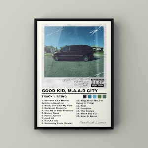 Puede incluir: Un póster enmarcado con la portada del álbum "Good Kid, M.A.A.D City" de Kendrick Lamar. La imagen muestra una furgoneta oscura en una calle, con el título del álbum y la lista de canciones debajo. El póster tiene un marco negro.