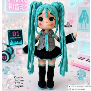 May include: A crocheted doll featuring long teal hair in twin tails, large black eyes, and pink cheeks. The doll wears a grey sleeveless top with a teal tie, a black pleated skirt, black arm warmers with teal cuffs, and black knee-high boots.
