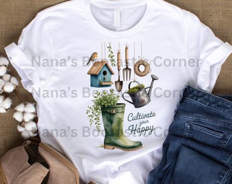 Puede incluir: Camiseta blanca con un diseño de acuarela de herramientas de jardinería, una casita para pájaros y una bota de agua verde llena de plantas. También se incluye el texto "Cultivate your Happy". La camiseta se combina con unos vaqueros azules.