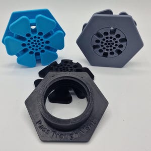 May include: Three hexagonal Pass Through Vents in blue, grey, and black. The blue vent has a flower-like design, the grey vent has a circular pattern, and the black vent has the words "Pass Through Vent" printed on it.