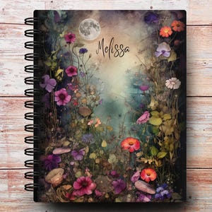 May include: A spiral bound journal with a watercolor design of flowers and a full moon. The cover features the name "Melissa" in a handwritten font.