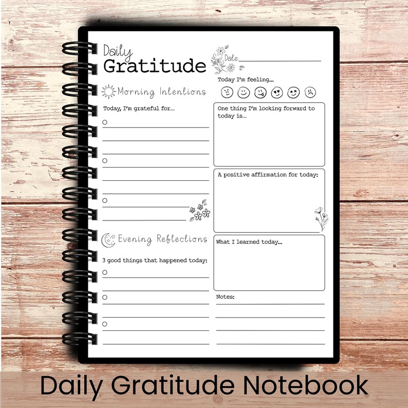 May include: A black spiral-bound notebook with the words "Daily Gratitude" on the top. The notebook has sections for morning intentions, evening reflections, and notes. The bottom of the notebook reads "Daily Gratitude Notebook".