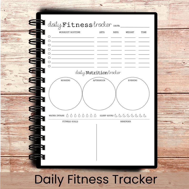 May include: A spiral-bound fitness tracker notebook with a black cover. The white interior pages include sections for workout routines, nutrition, water intake, and sleep hours. The text "Daily Fitness Tracker" is at the bottom.