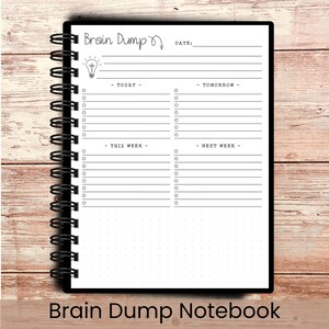 May include: A black spiral-bound notebook with the words "Brain Dump" and a lightbulb graphic at the top. The notebook has sections for "Today," "Tomorrow," "This Week," and "Next Week," with lines and checkboxes for notes. The words "Brain Dump Notebook" are at the bottom.