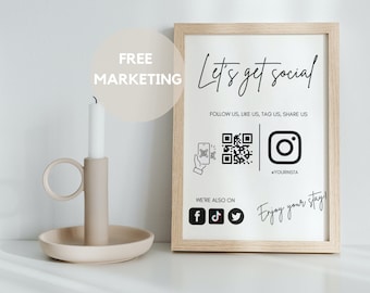 Może przedstawiać: Biały znak w ramie z tekstem "Let's get social!" i ikonami mediów społecznościowych, w tym kodem QR, Instagramem, Facebookiem, Twitterem i TikTokiem. Znak zawiera również tekst "Follow us, like us, tag us, share us" i "Enjoy your stay". Znak znajduje się na białej powierzchni z świecznikiem i białą świecą.