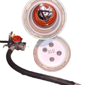 May include: A disassembled fire extinguisher with a black hose and a red pressure gauge. The top of the extinguisher is open, revealing an orange interior. The bottom cap is white with the number "011" printed on it.