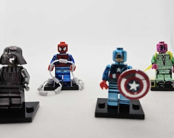 May include: Four superhero-themed Lego minifigures on black bases. Includes Darth Vader in black, Spider-Man in red and blue with web accessories, Captain America with shield, and Vision in green and pink.