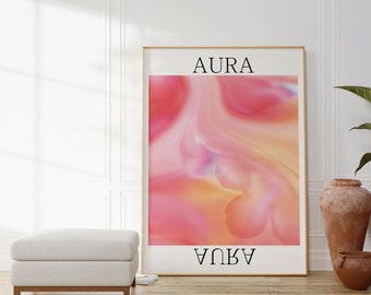 May include: A framed art print with the word "AURA" at the top and "AQUA" at the bottom. The artwork features a vibrant, abstract design with swirling shades of pink, orange, and yellow. The print is displayed in a room with a white ottoman and decorative vases.