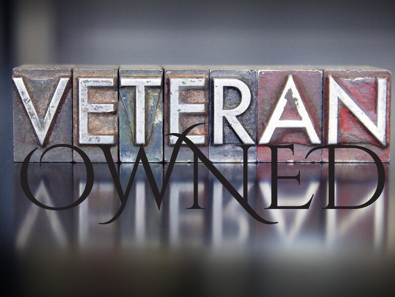 Peut inclure: Les mots "Veteran Owned" sont &eacute;pell&eacute;s en lettres m&eacute;talliques en relief, avec un reflet des lettres sur une surface brillante en dessous.