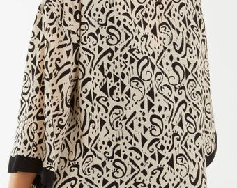 May include: A black and white patterned kimono with a black trim. The kimono is made of a lightweight fabric and has a relaxed fit.