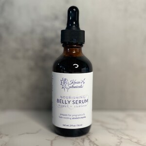 Puede incluir: Una botella de vidrio marr&oacute;n con un gotero, etiquetada "Nourishing Belly Serum" con el texto "kukui + tamanu" y "prepare for pregnancy & fade existing stretch marks". La botella contiene 56 ml de suero.