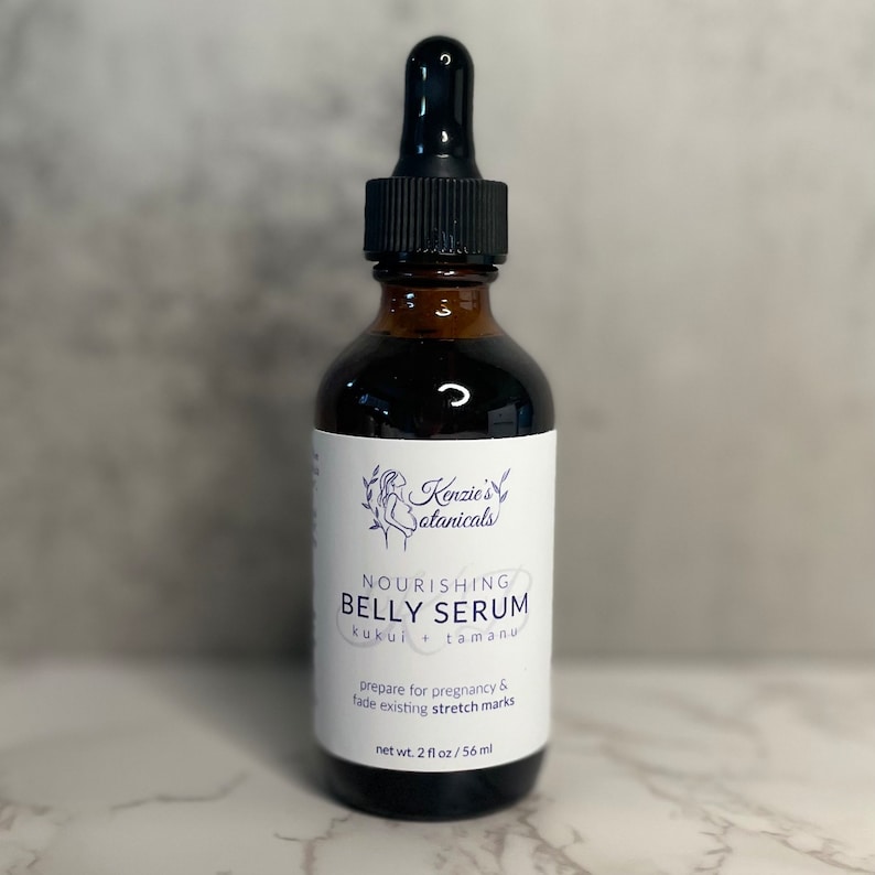 Puede incluir: Una botella de vidrio marr&oacute;n con un gotero, etiquetada "Nourishing Belly Serum" con el texto "kukui + tamanu" y "prepare for pregnancy & fade existing stretch marks". La botella contiene 56 ml de suero.