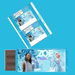 Puede incluir: Plantilla de envoltorio de barra de chocolate Hershey's con una escena de invierno azul y blanco con una ni&ntilde;a y Elsa de Frozen. El texto "ZOE Turns 9" est&aacute; en el envoltorio.