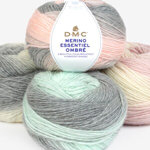 Könnte beinhalten: Drei Knäuel Garn in Ombre-Farbtönen von Rosa, Grau und Grün. Das Garn ist mit "D-M-C Merino Essentiel Ombr" gekennzeichnet. Ein wunderschöner Farbeffekt in Farbverläufen.