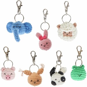 May include: A collection of handmade crochet animal keychains, including a blue elephant, pink bunny, white sheep, pink pig, tan bunny, black and white cow, and green frog. Each keychain has a silver-colored clasp and ring.