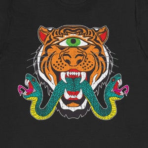 May include: Black t-shirt featuring a graphic of a tiger with a third eye and two snakes wrapped around its mouth.