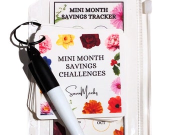 May include: A clear plastic zippered pouch with a ring and a black dry-erase marker. The pouch contains a set of colorful cards with floral designs and the text "Mini Month Savings Challenges".