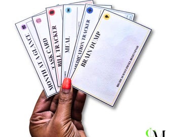 May include: A set of white rectangular planner cards with black text and colorful icons. The cards are labeled Month at a Glance, Task Card, Bill Tracker, Meal, Medication Tracker, and Brain Dump, with the text Big Ideas Have Small Beginnings.